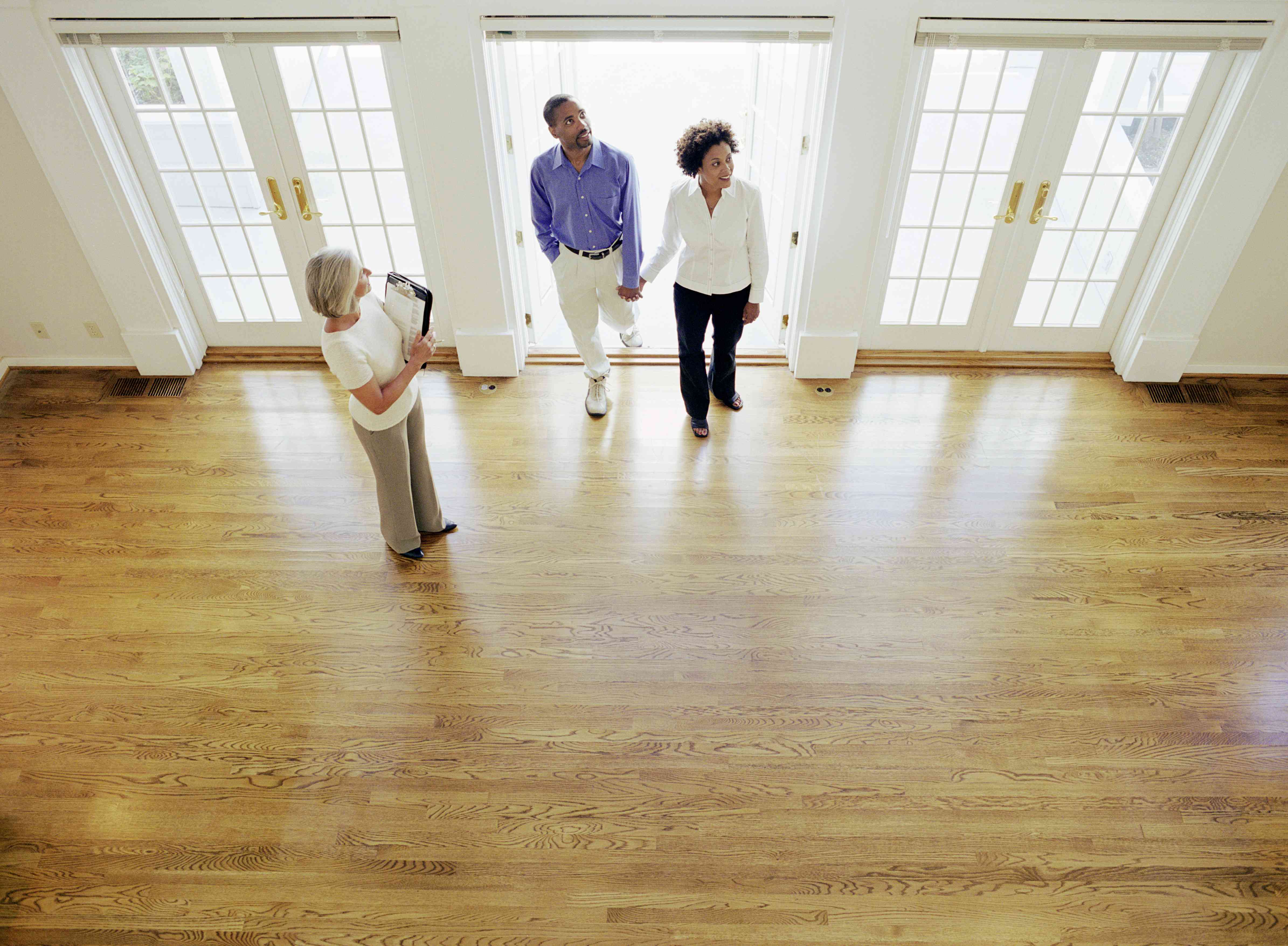 realtor showing couple interior of house, elevated view