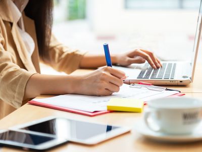 Asian woman using laptop at home while sitting the wooden table.hands typing on the notebook keyboard. Online training education and freelance work. Computer, laptop and studying remotely.