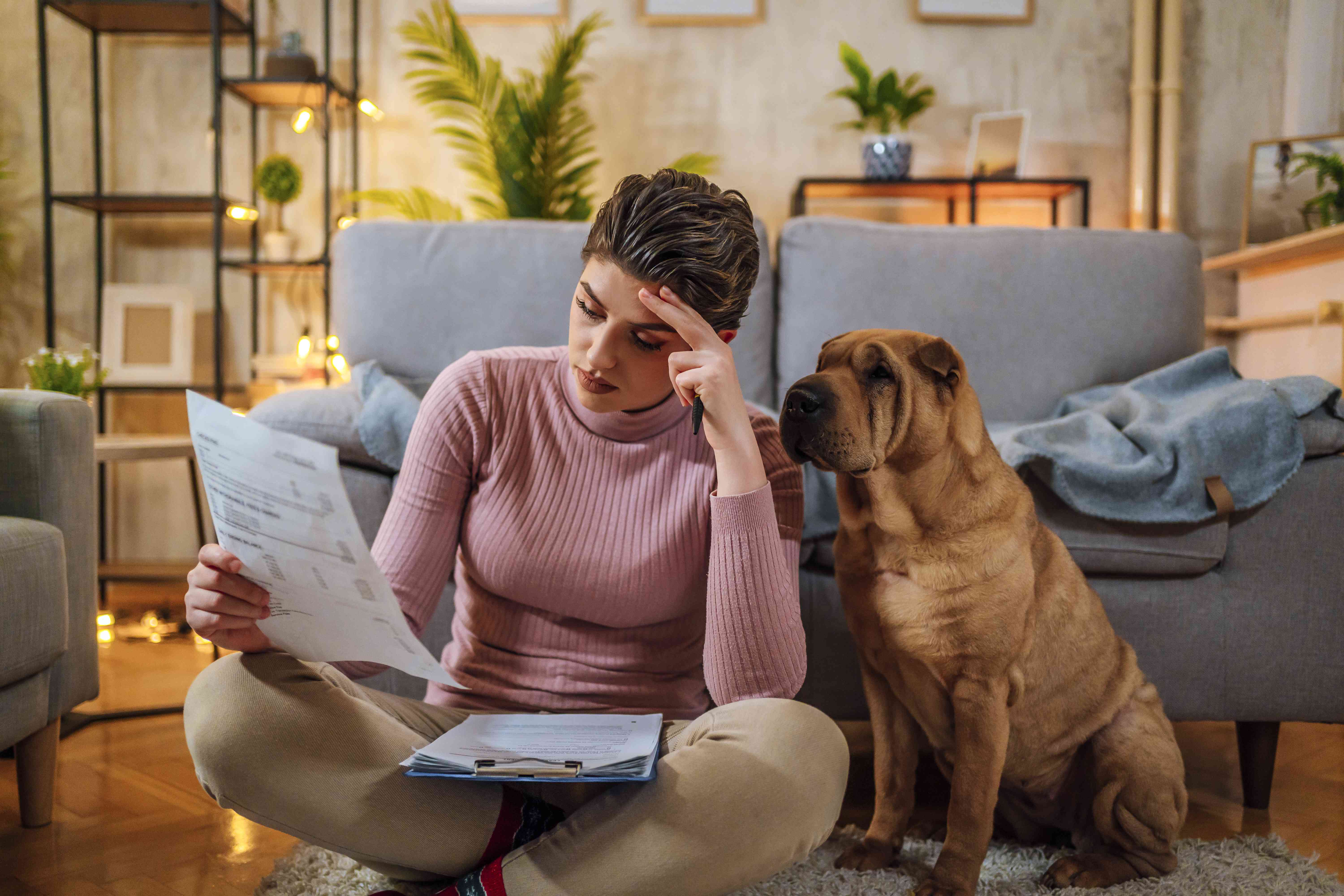 Woman sitting at home with her dog worried about her early withdrawal penalty