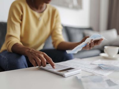 Close up of adult woman checking her bills at home, personal loans