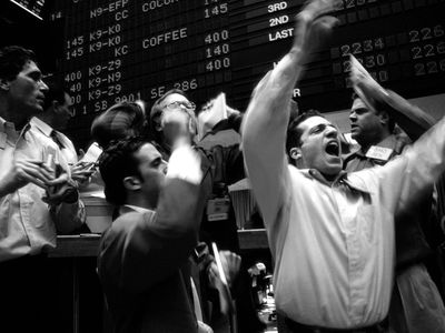 A group of floor traders gester and shout during trading on the floor of the Coffee, Sugar, and Cocoa Exchange in New York City.