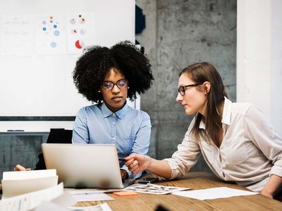 Two young women having a discussion in a business about background checks