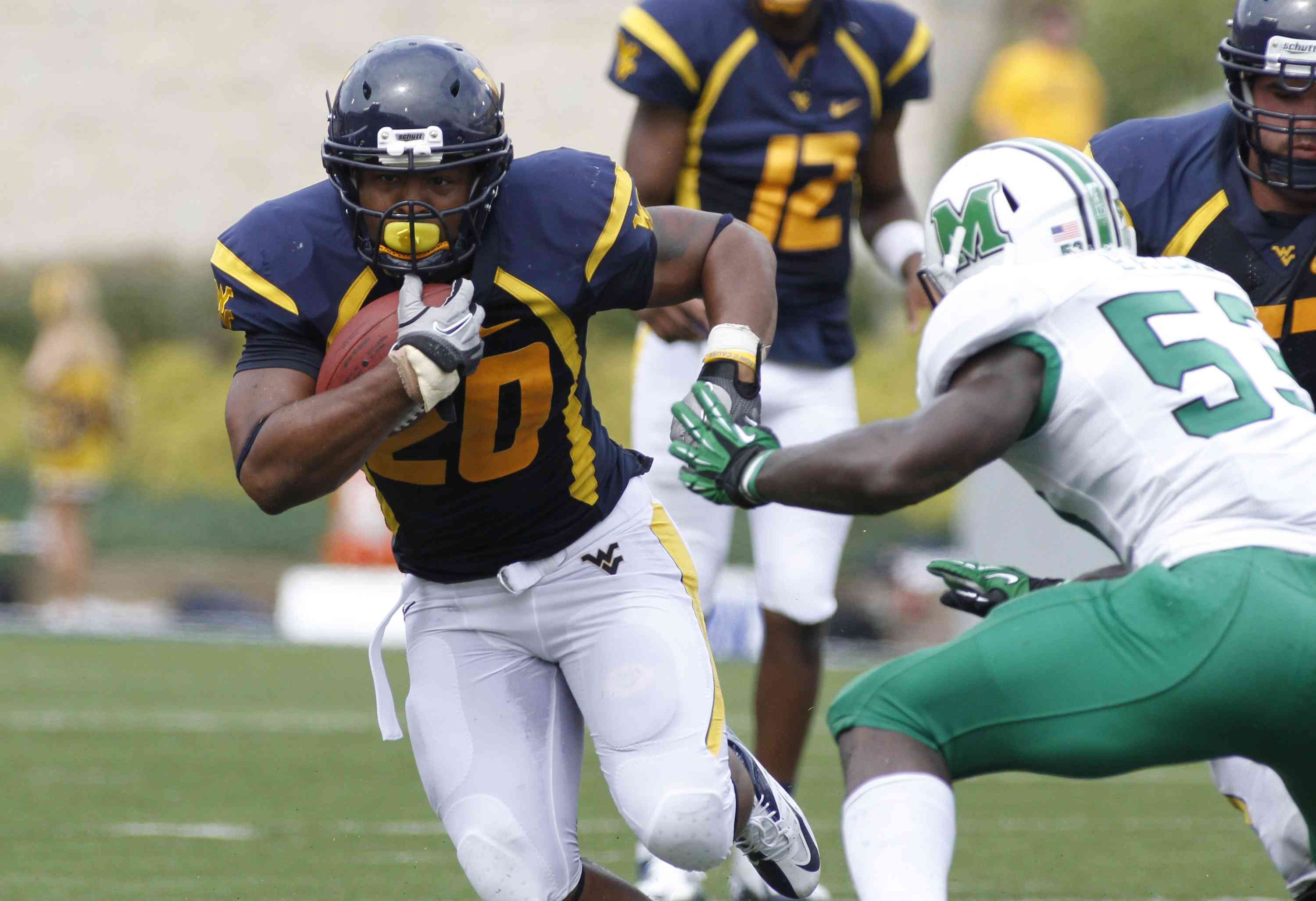 Shawne Alston (20) of the West Virginia Mountaineers carries the ball against the Marshall Thundering Herd