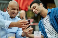 father son looking at a smartphone