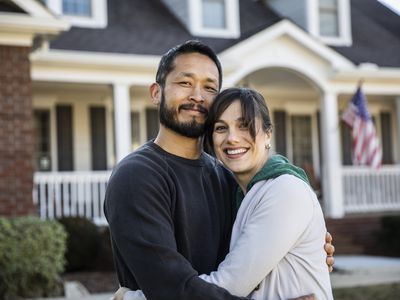 Couple embracing in front of a home