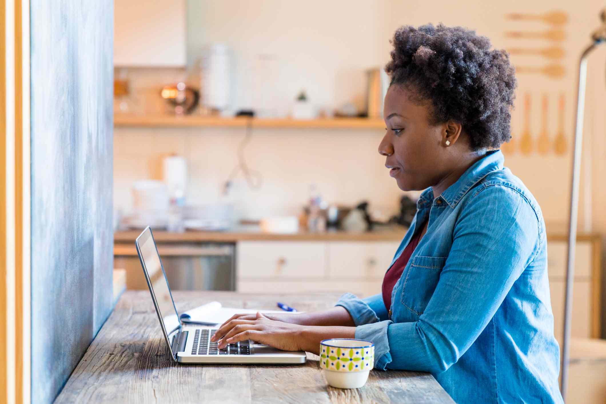 Young adult female working/ studying from home using her laptop computer