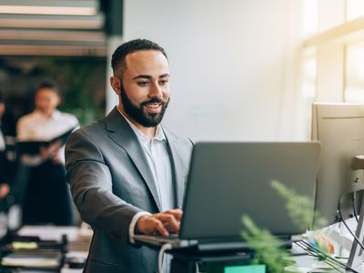 A man in a business suit uses a computer.