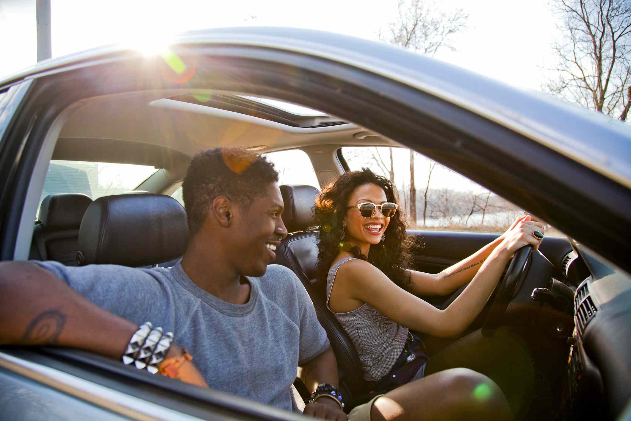 A couple drives a rental while on vacation in Colorado.