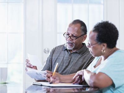 A couple sitting at a table review documents.