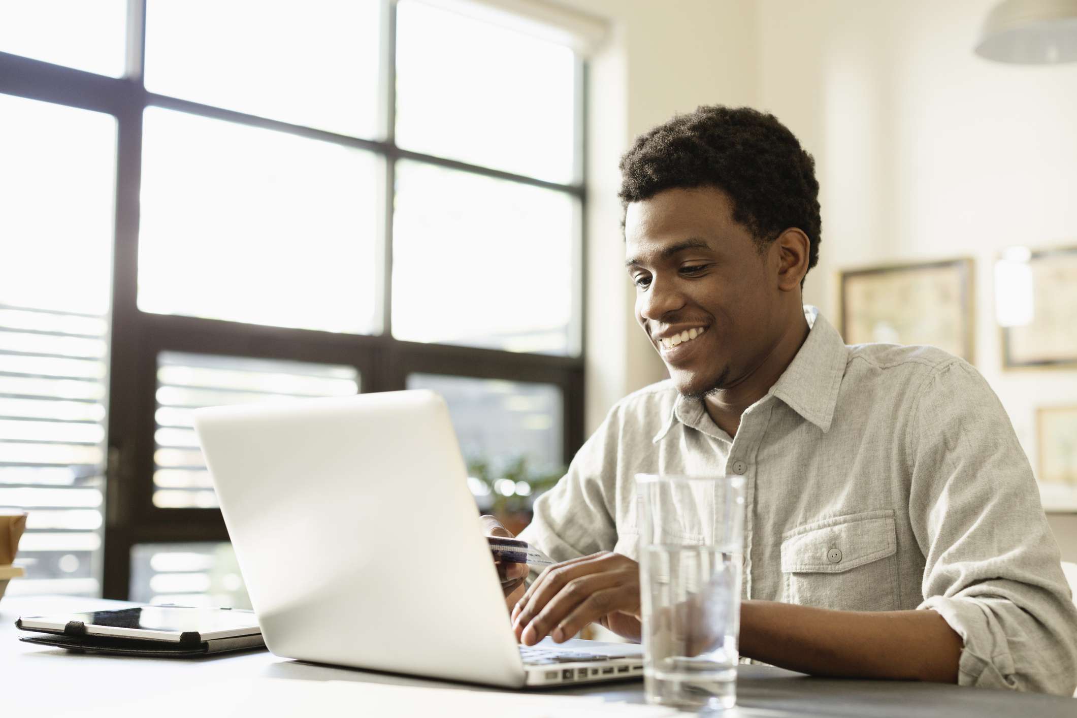 Young man at laptop, calculating loan costs