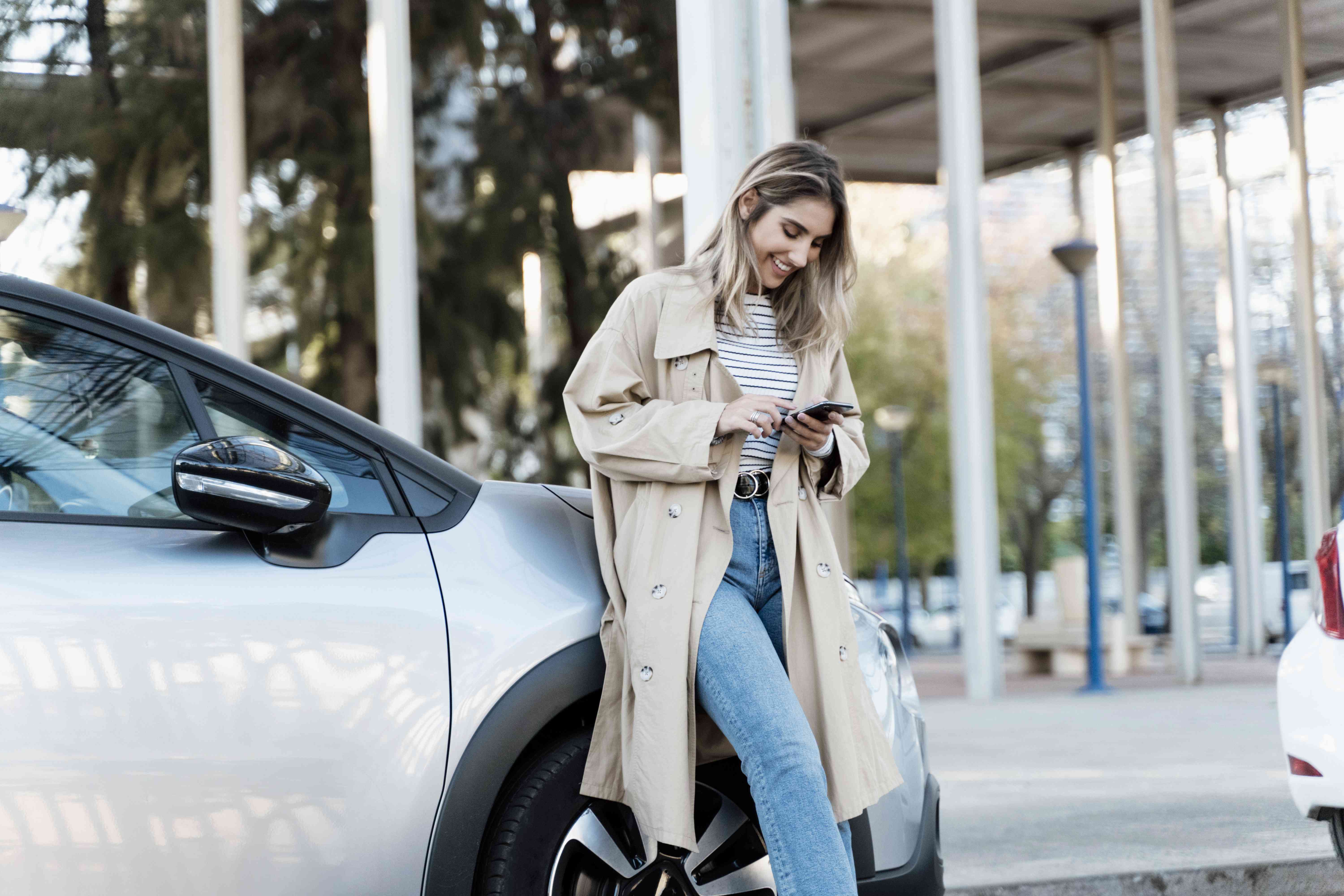 Woman Leans on Car, Uses Phone