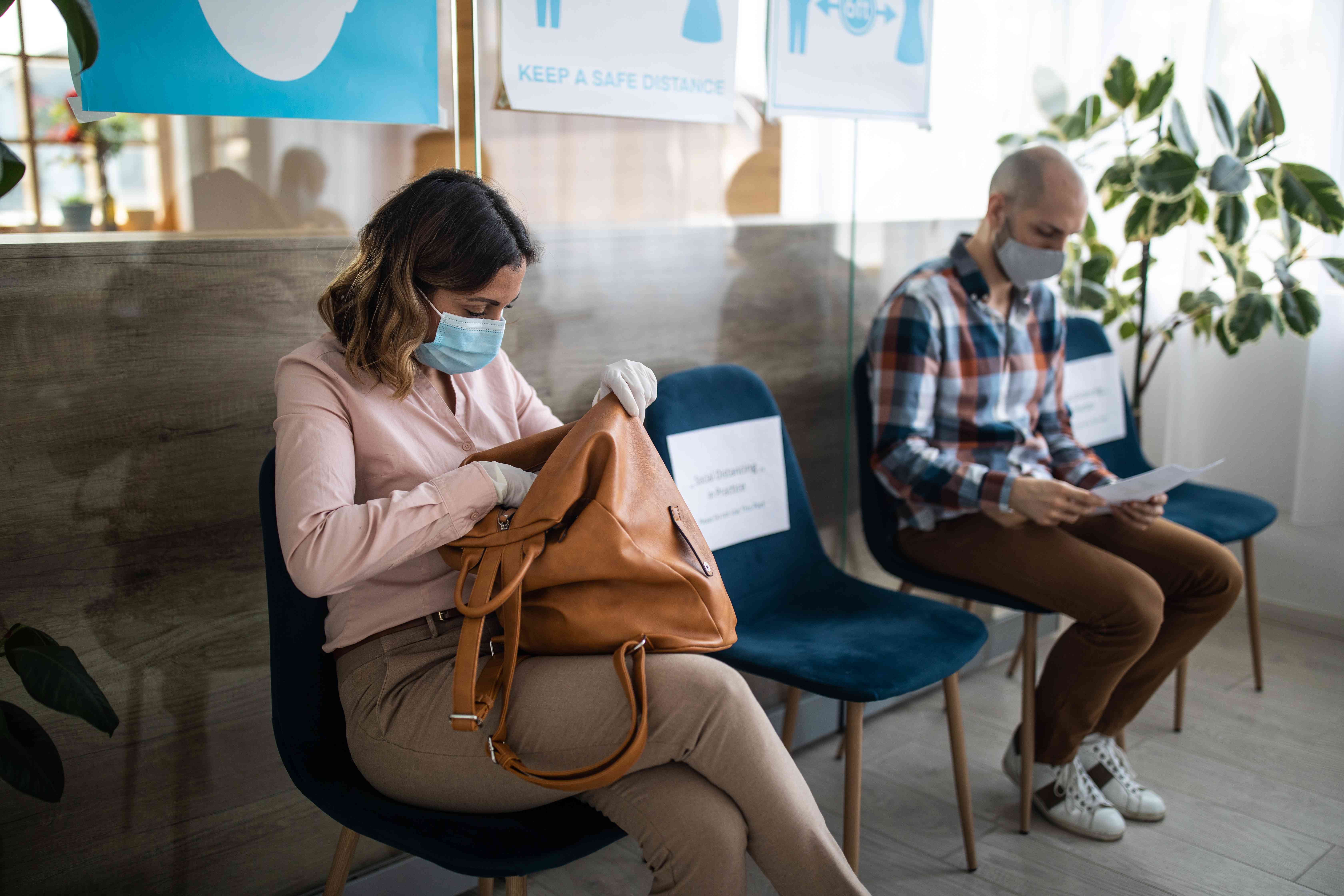 People sit outside social service office for their unemployment benefits appointments.