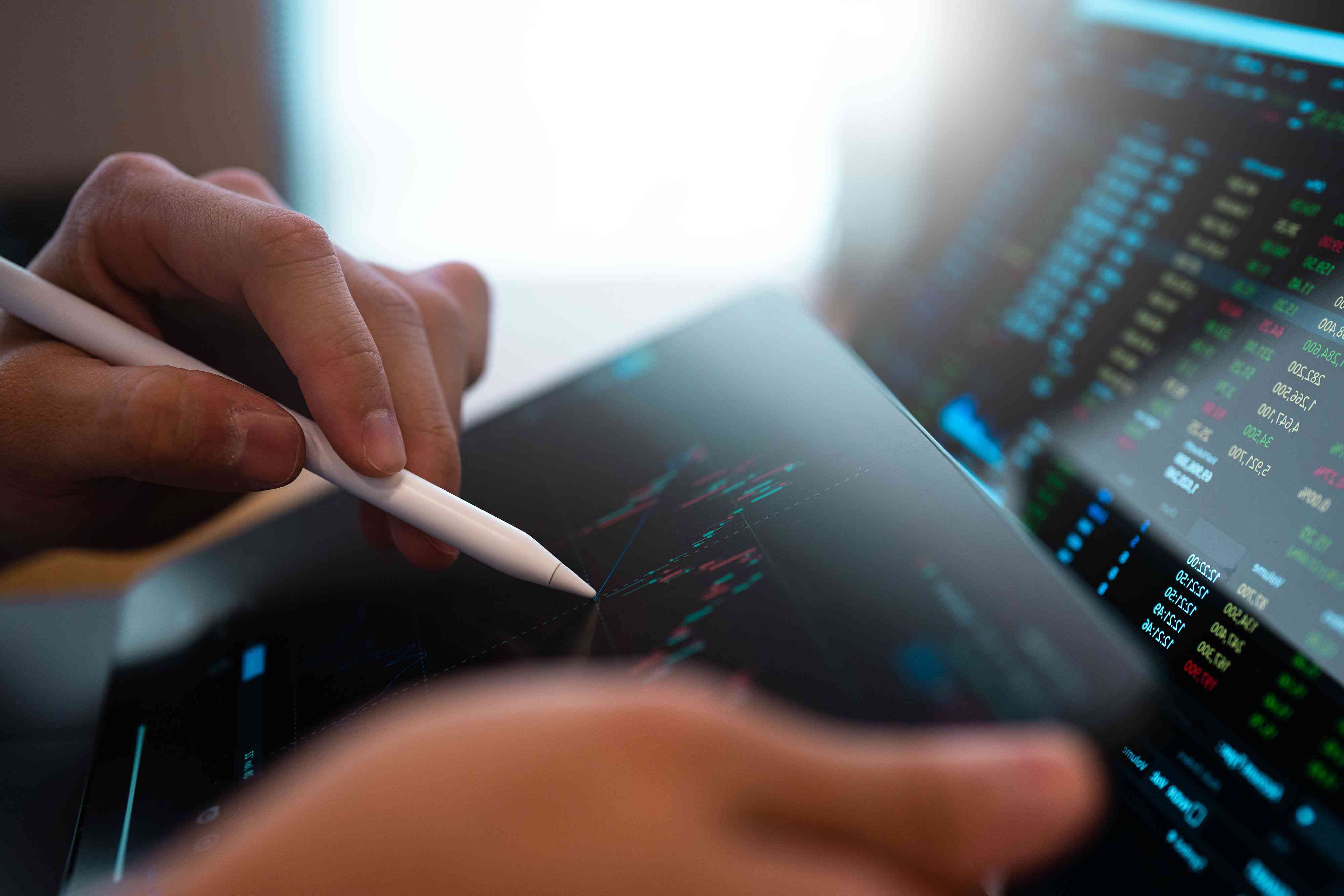 A business person tracking the technical movement of a stock chart on a computer screen