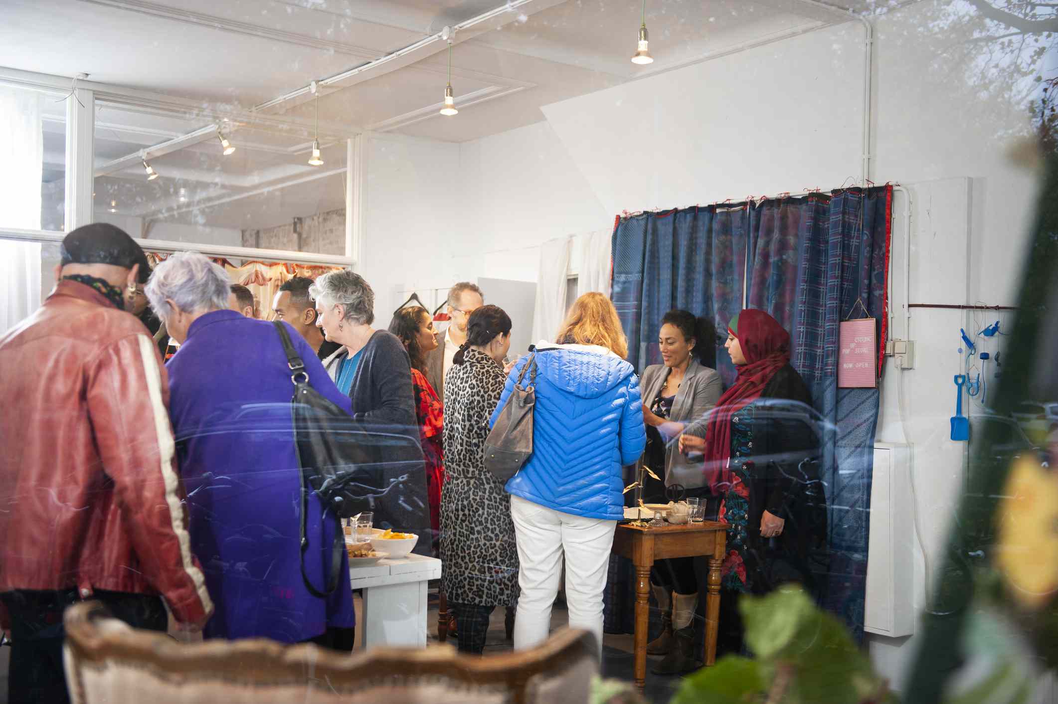 People at the counter of a creative popup store and in the shop.