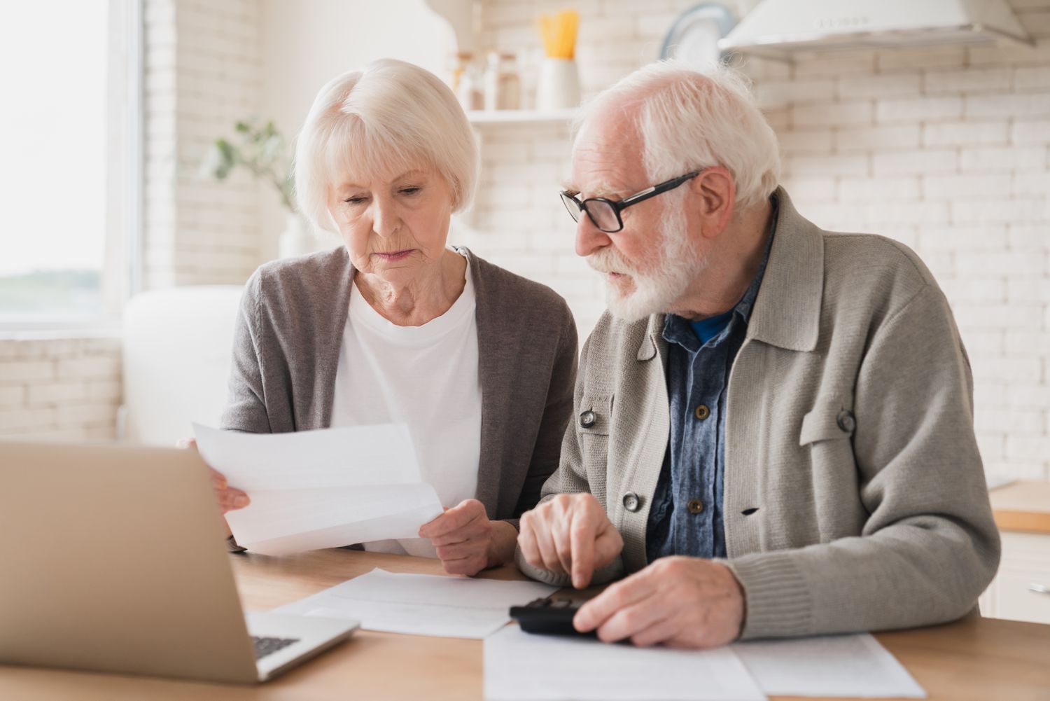 An older couple reviews documents at a table.