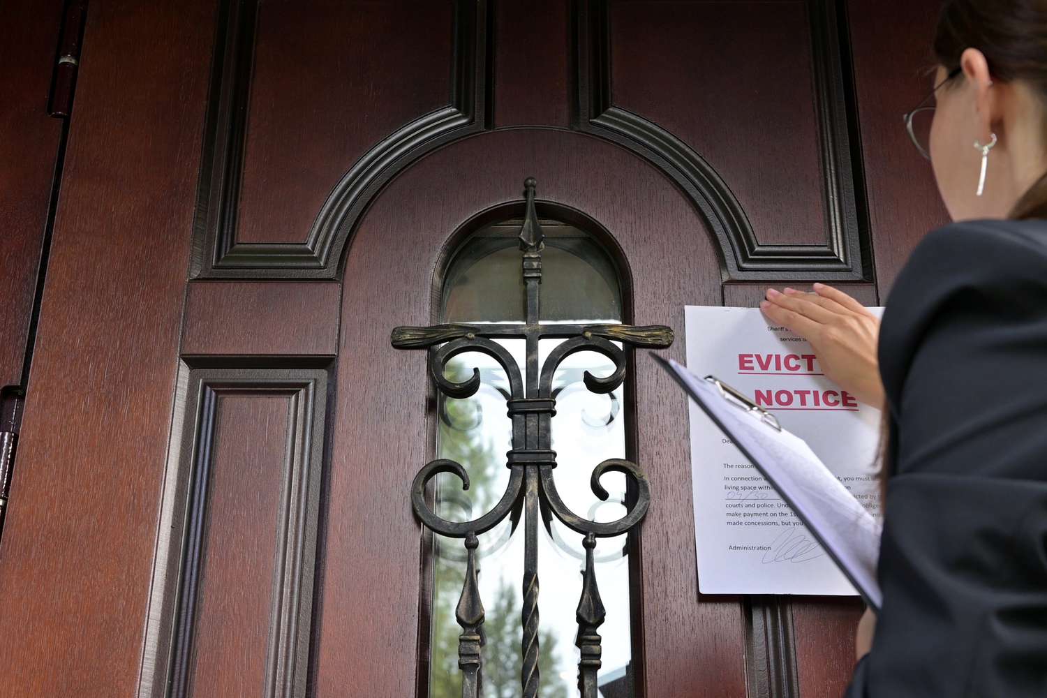 Civil servant putting eviction notice on a door to enforce a writ of execution.