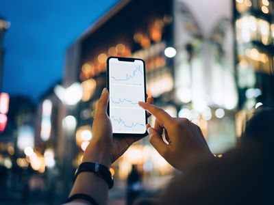 Businesswoman reading financial trading data on smartphone