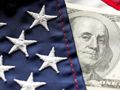 Close-up of U.S. flag and $100 U.S. bill