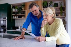 Couple reading a letter in their kitchen