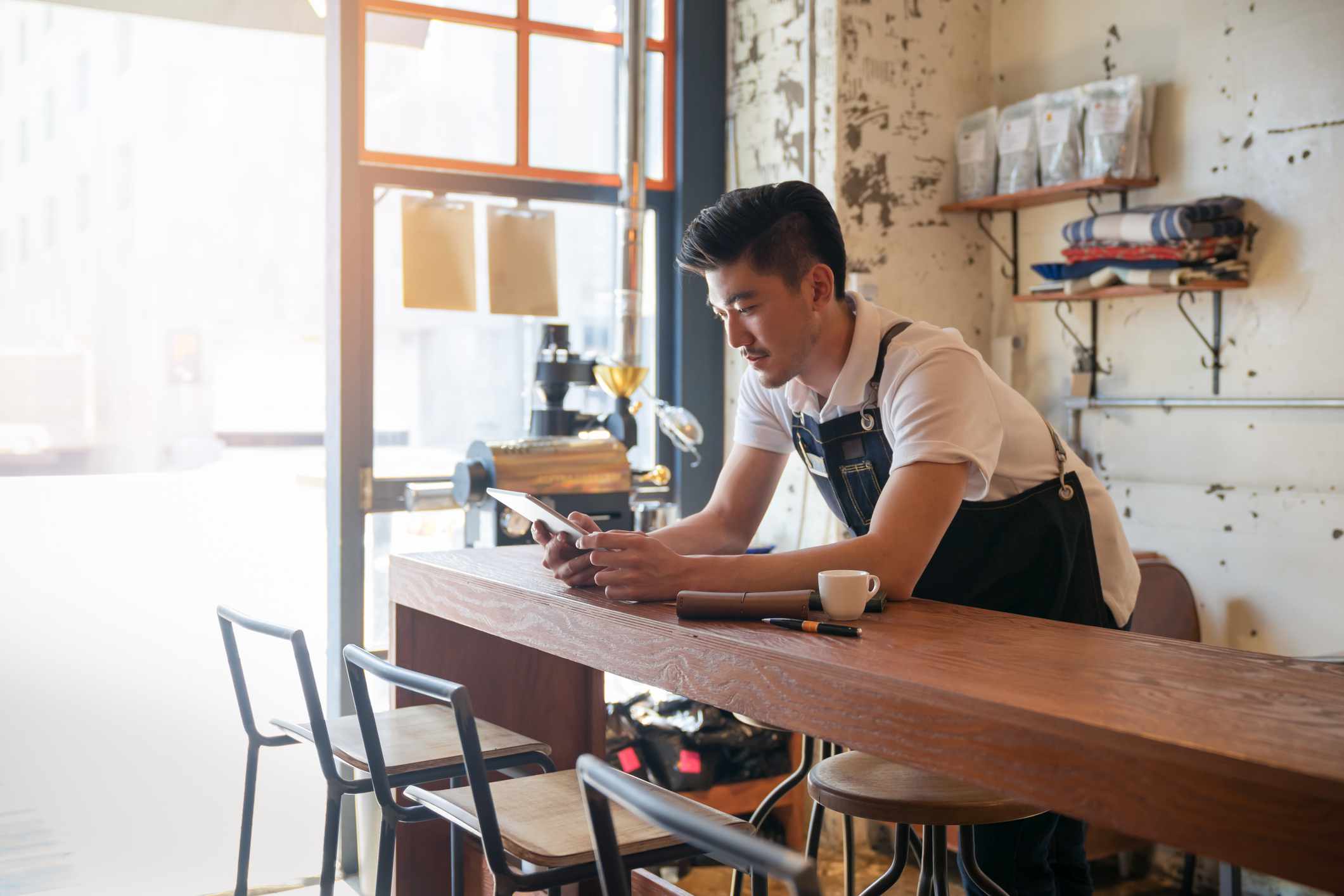 A business owner reviews information on a device.