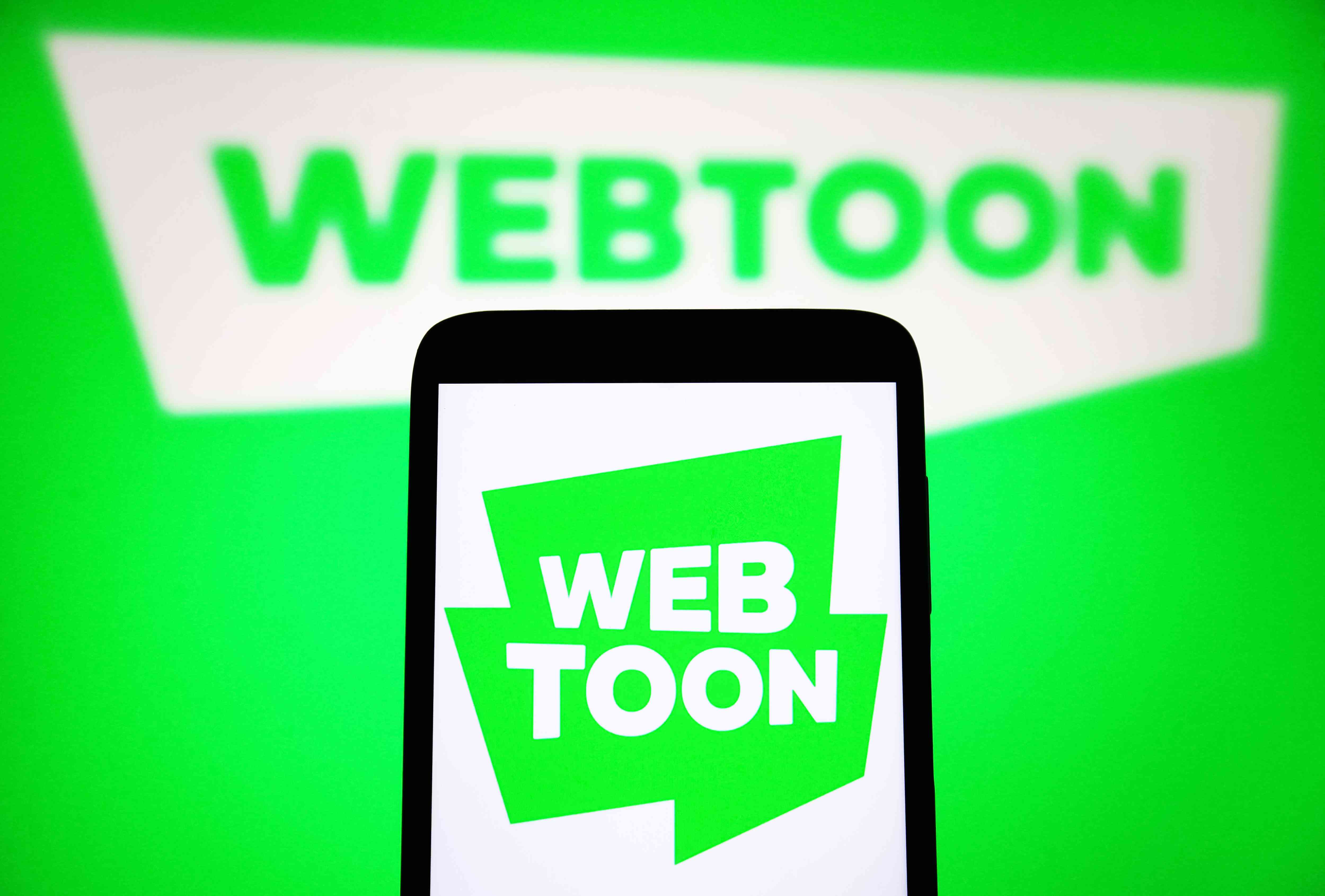 A Webtoon Entertainment Inc. logo is seen on a smartphone and on a PC screen