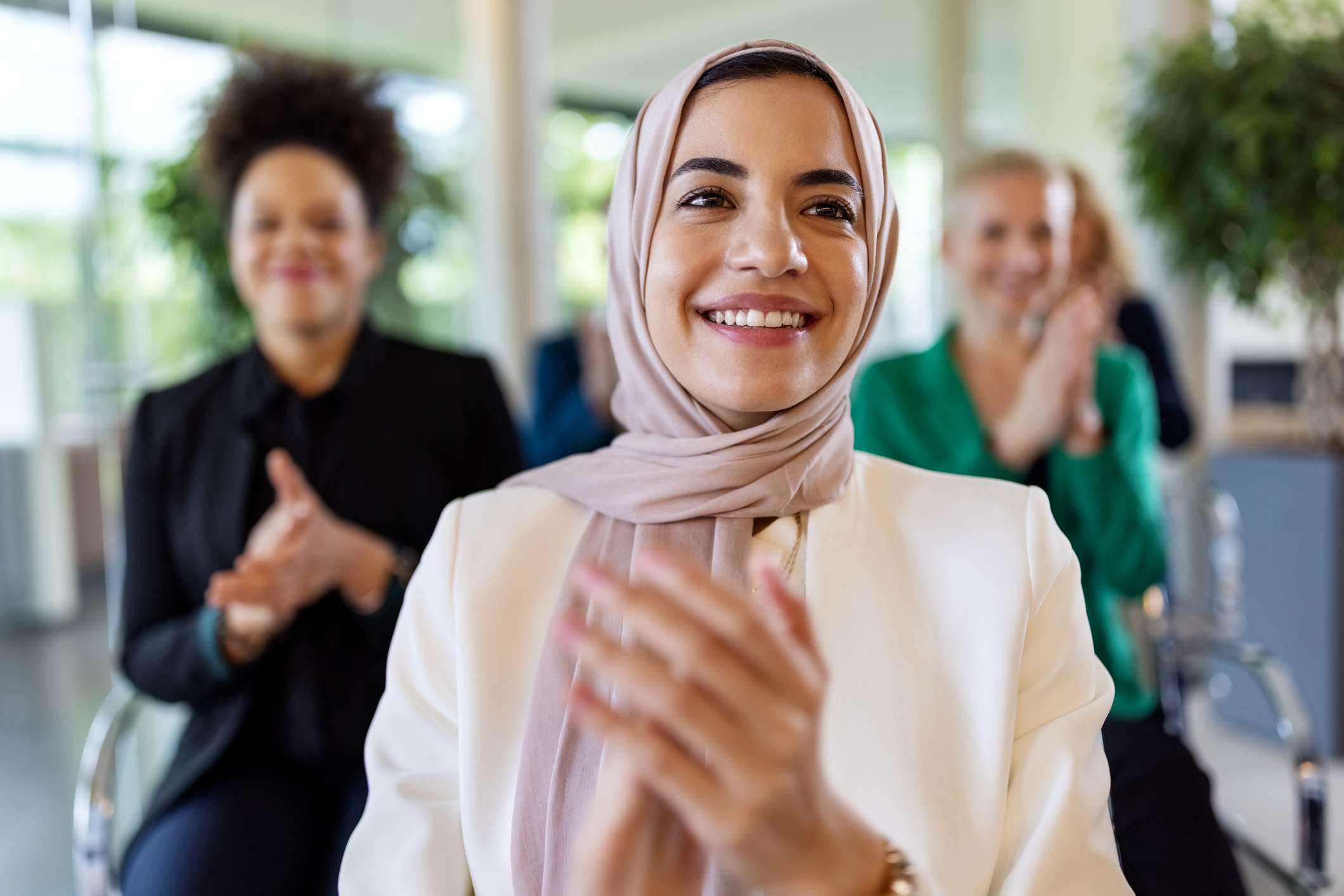 Woman clapping wearing a headscarf.