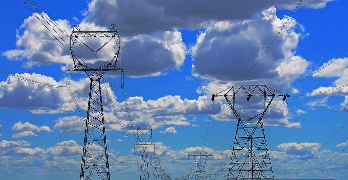 Power lines against a blue sky with white clouds