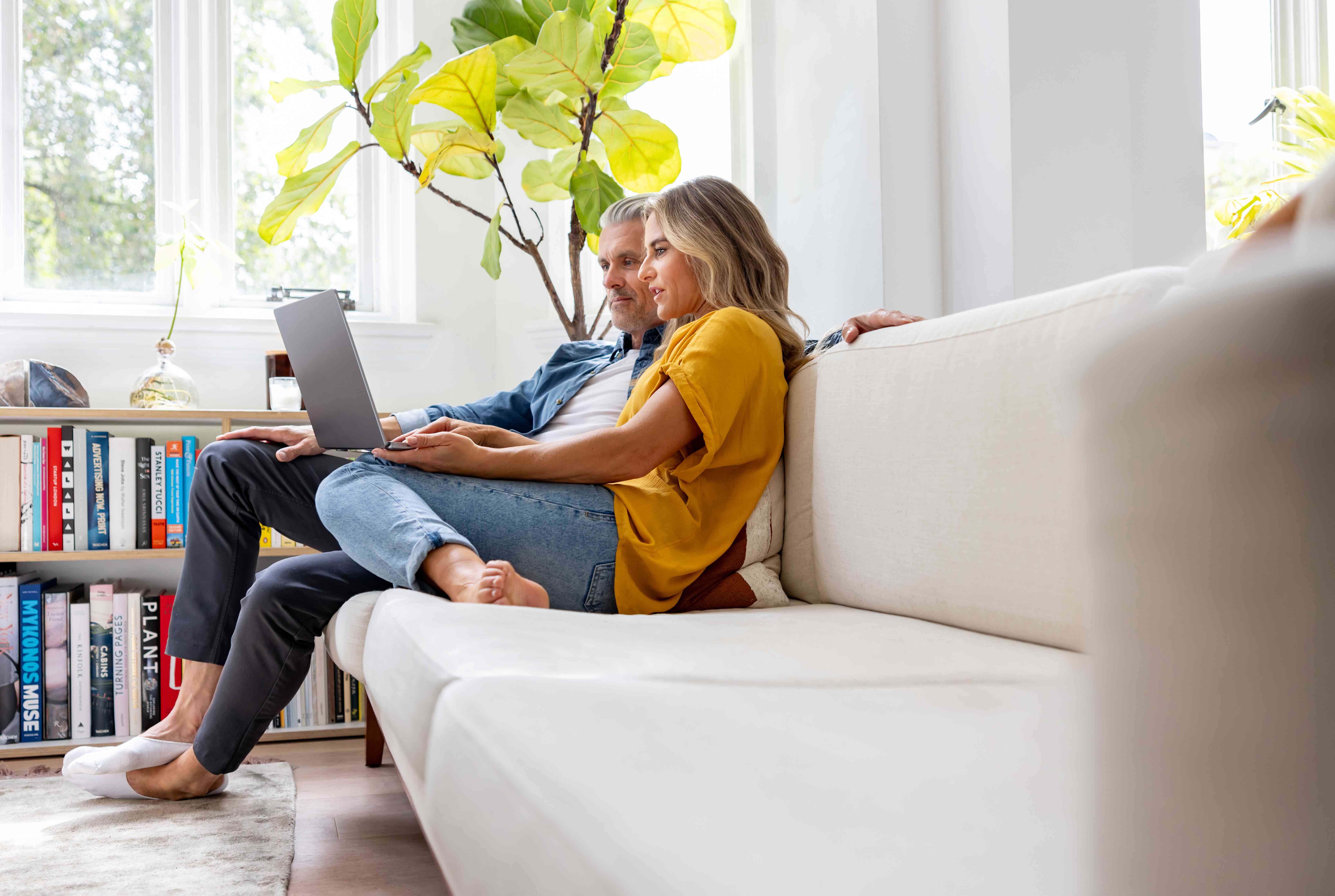 Couple using laptop on couch