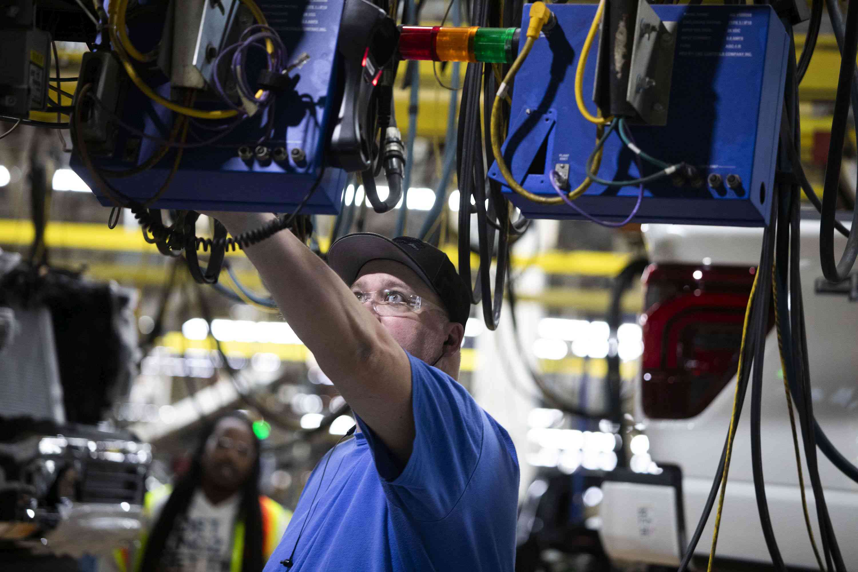 An employee works on new Ford F-150 trucks as they go through the assembly line at the Ford Dearborn Plant