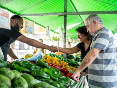 Salesman greeting customers on a street market