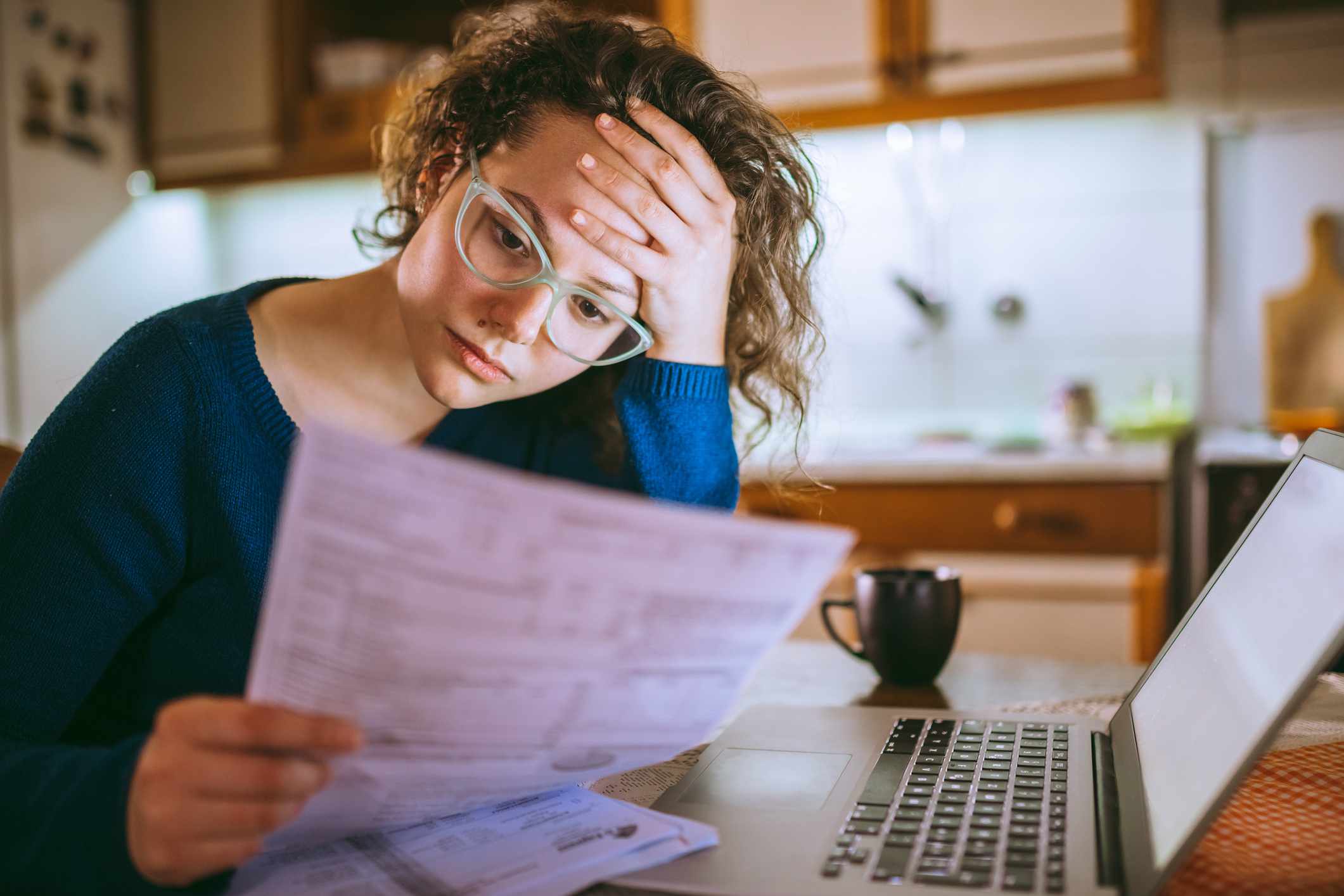 A person stresses over financial documents.