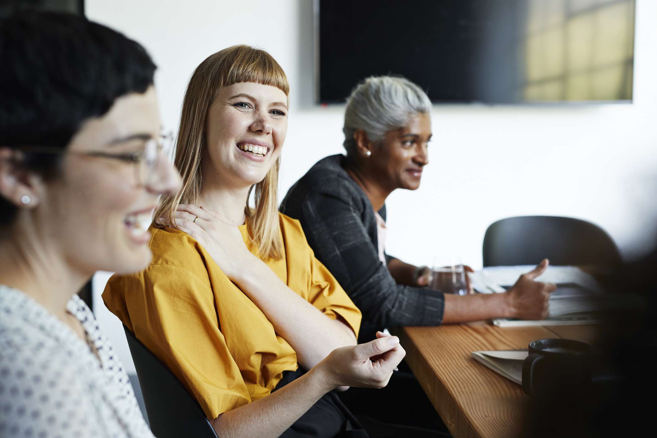 Three Women of Different Ages Sitting at a Conference Table