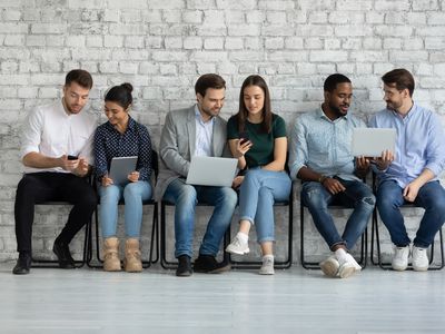 Three couples sitting in a row holding tablets and talking to each other