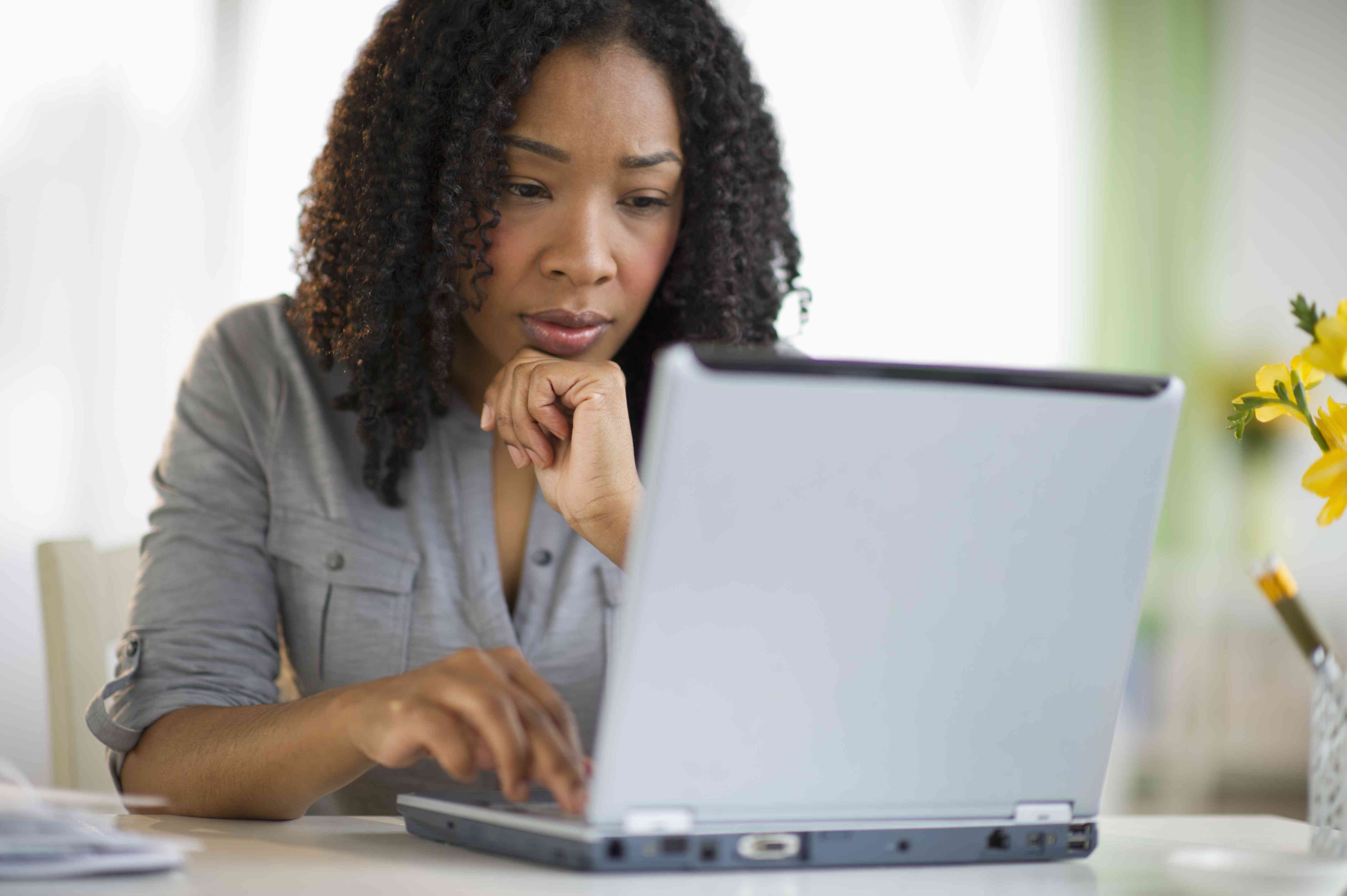 Black woman looking at a laptop computer