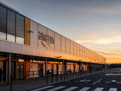 The Amazon logo appears on the facade of one of the company's buildings in France at sunset.