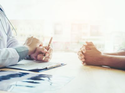 Medical proxy and doctor sit across a desk to review difficult choices