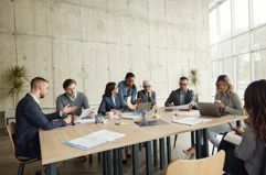 Corporate team at conference table discussing a takeover bid