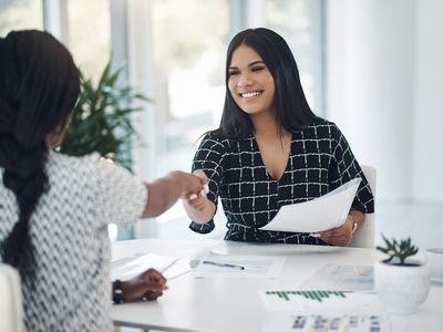 Two young businesswomen shaking hands