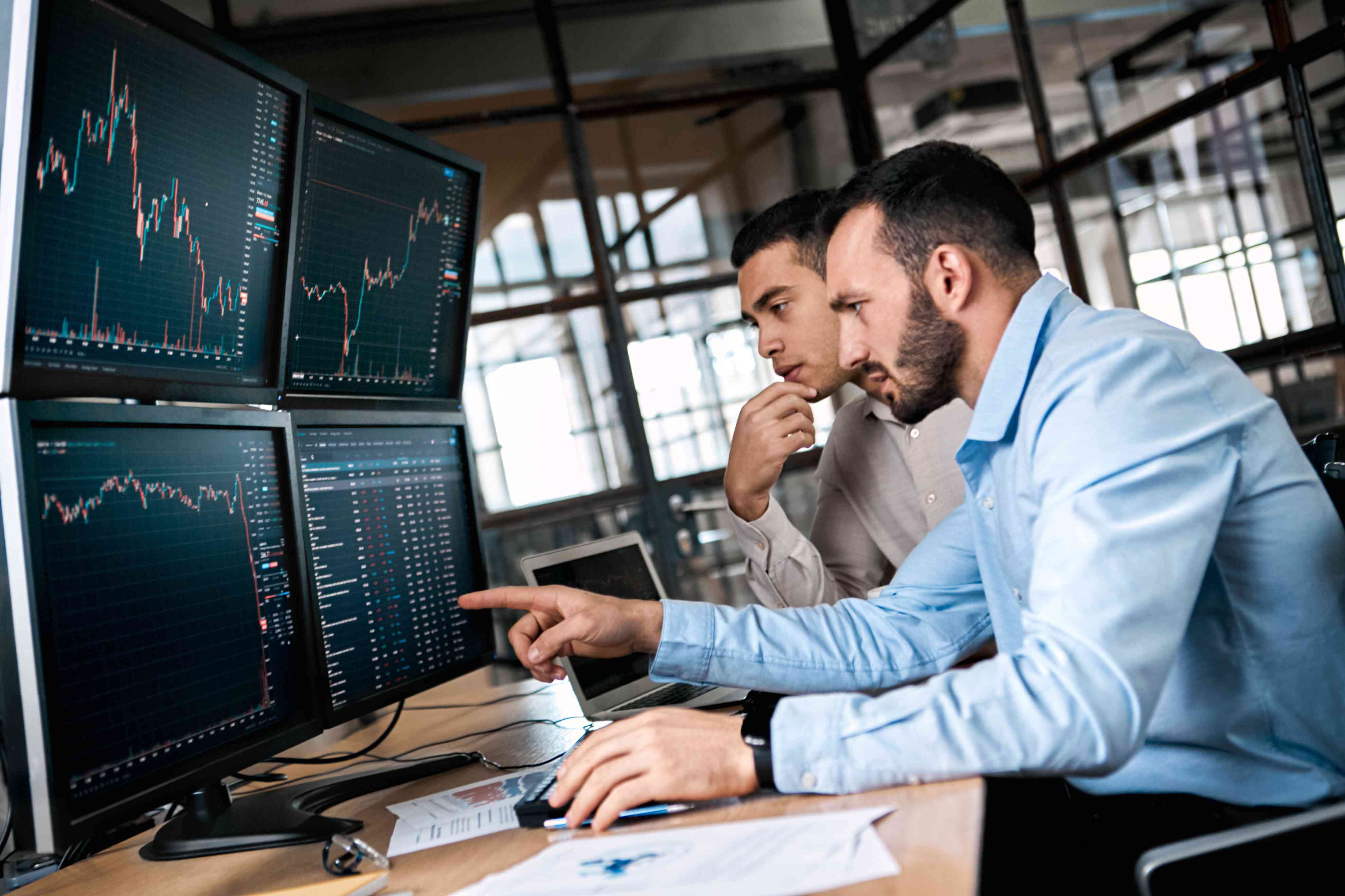 Two men working together reviewing a forex chart. 