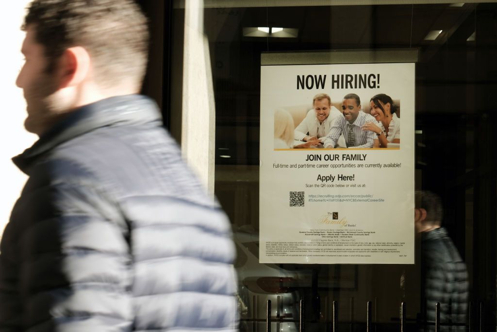 A 'now hiring' sign is displayed in a window of a store in Manhattan on December 02, 2022 in New York City. 