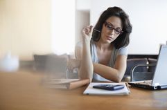 Woman at desk with bills. 