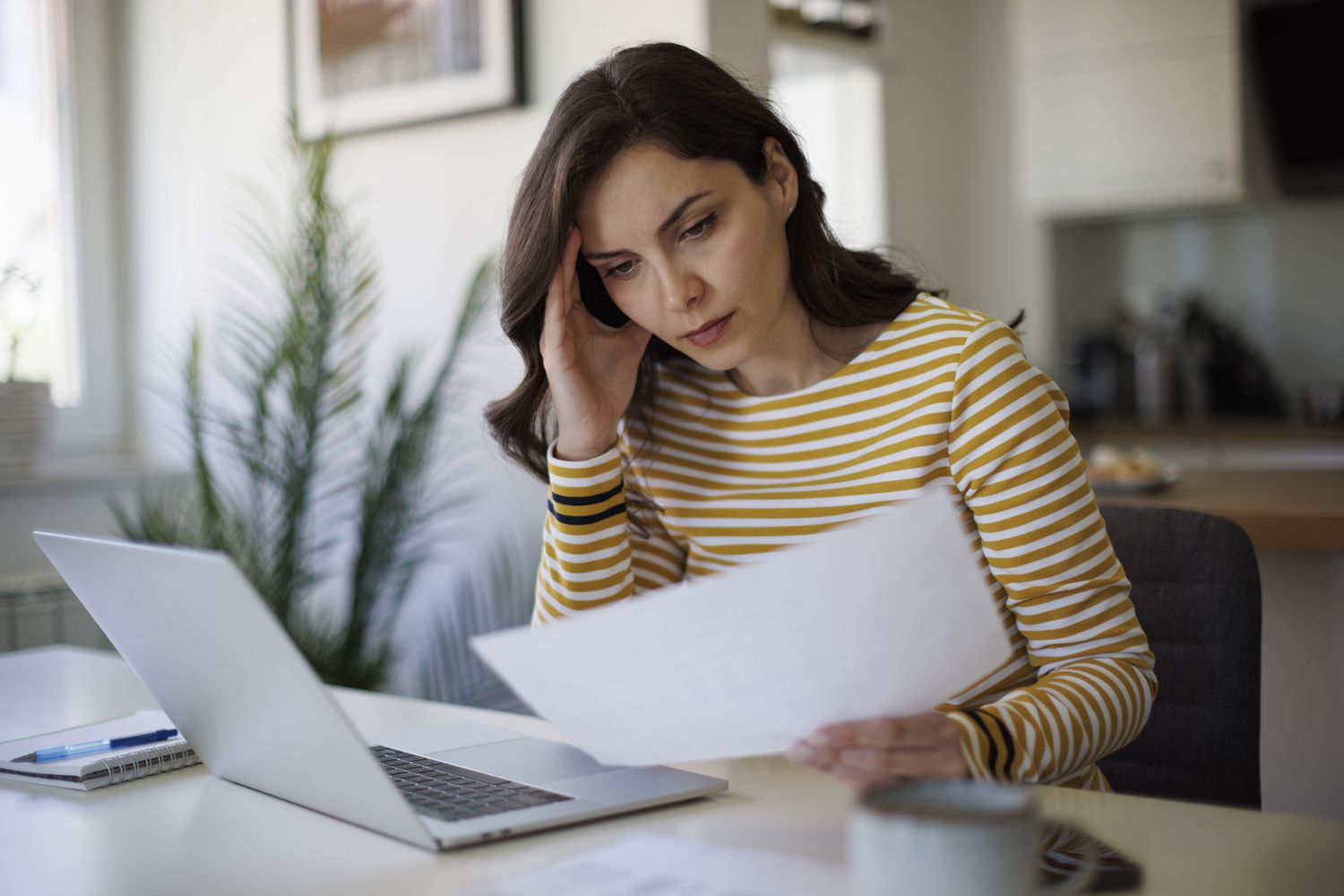 A woman is stressed as she reads documents.