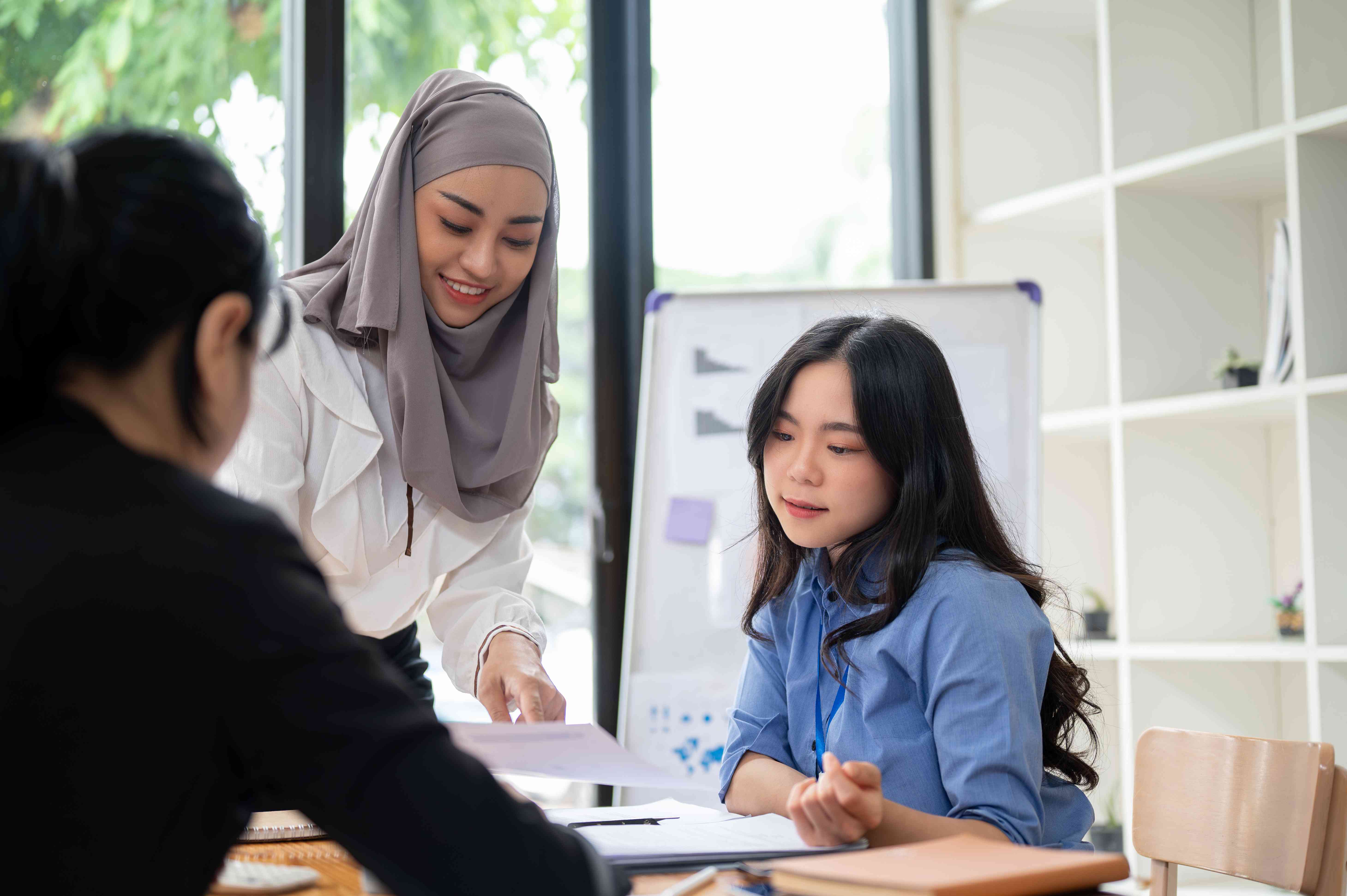 Asian Muslim Female Banker explaining about the union to her customer