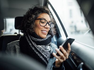 Middle-aged woman reading phone in car