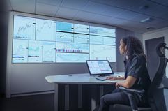 Woman studying trading charts on multiple screens