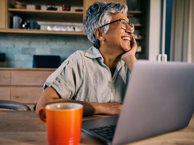 Smiling worker in kitchen with computer