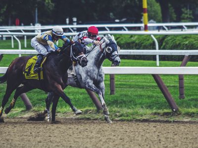 Two jockeys vie for the advantage in a horse race.