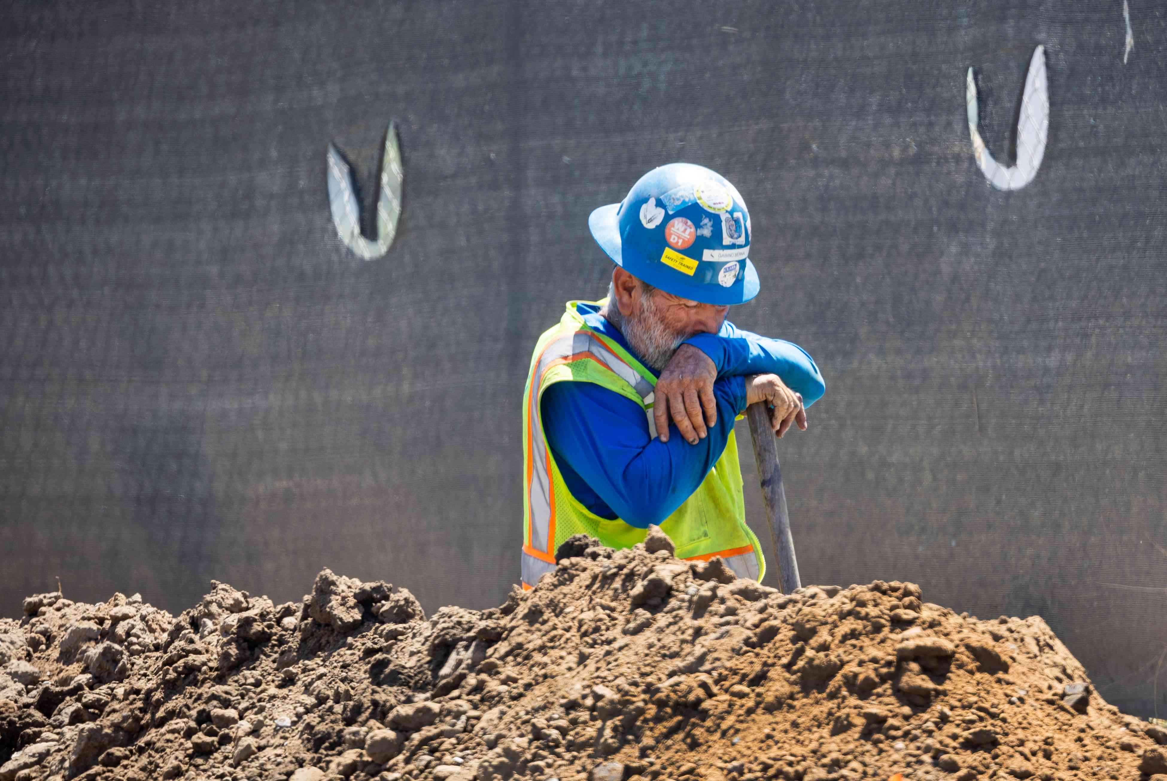 A construction worker takes a quick break while digging a trench with a shovel amidst a heat wave in Irvine Thursday, Sept. 5, 2024