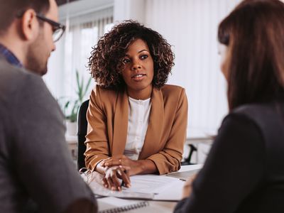 Couple consulting with a female financial manager at the bank