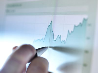 Hand of a Stock Broker Analyzing Line Graph on Computer Screen